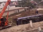 Сорвавшийся с трассы тонар поднимают двумя кранами в станице Красноярской 