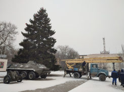Живую ель рядом с военной техникой украшают на площади Победы в Волгодонске