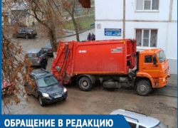 Объезжая засыпанную яму, мусоровоз застрял в сливном лотке во дворе на Строителей