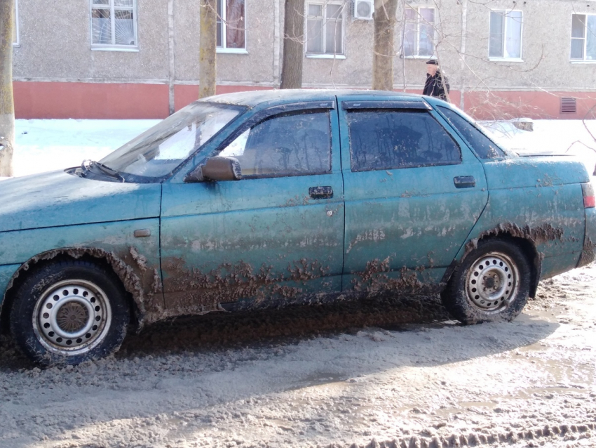 Припаркованные на обочине машины закидала грязью и снегом коммунальная техника 